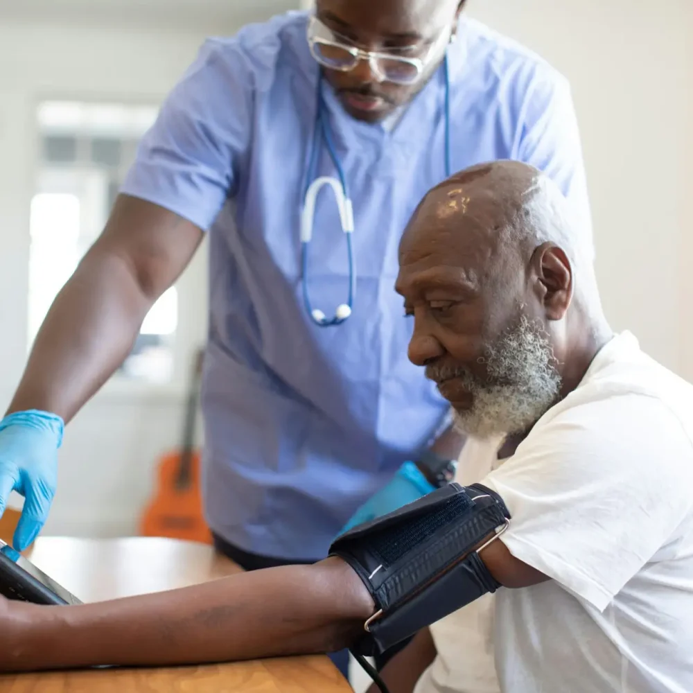 Healthcare provider checking a patient's blood pressure during a medical exam at Ahava Wellness Center