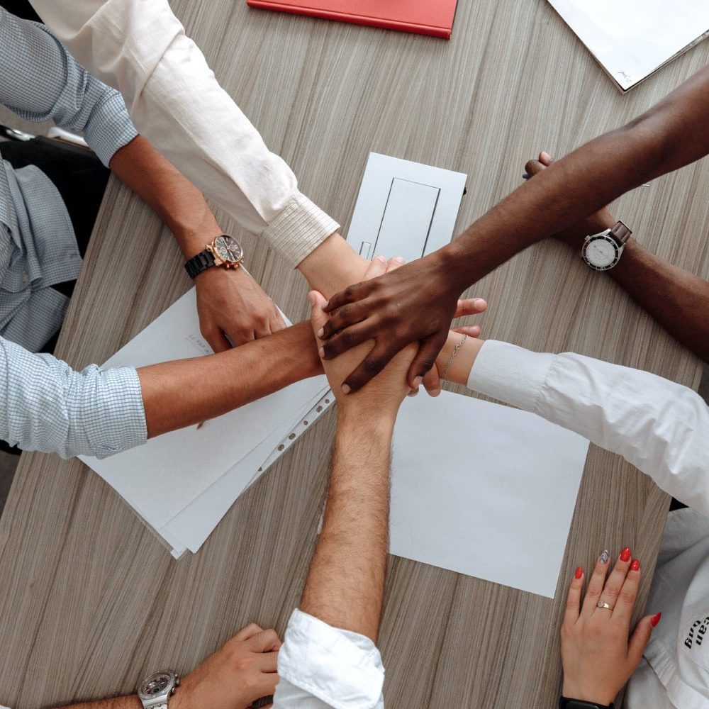 Ahava Wellness Center support team joining hands in a show of unity